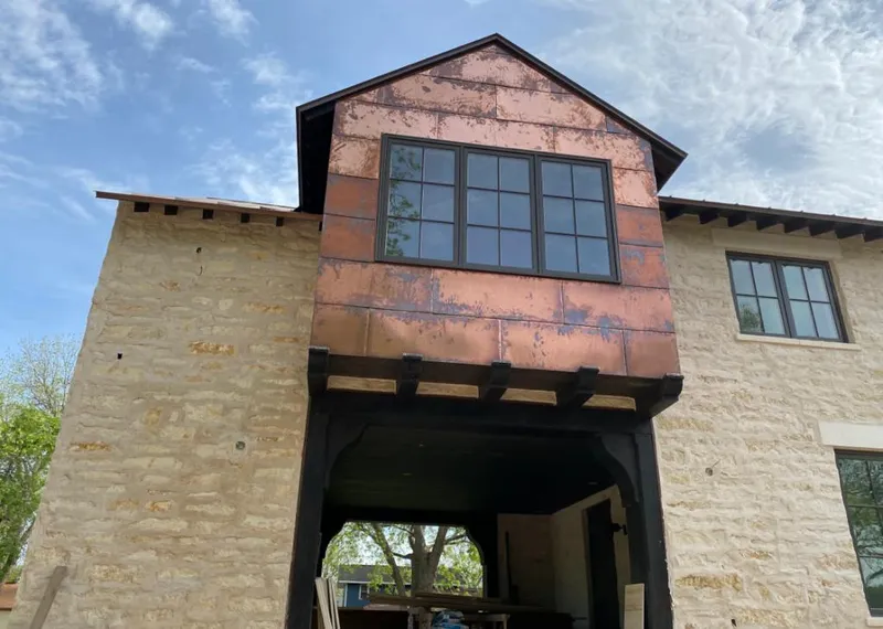 Copper metal panel facade on a stone building for Skylight Installation in Halfway